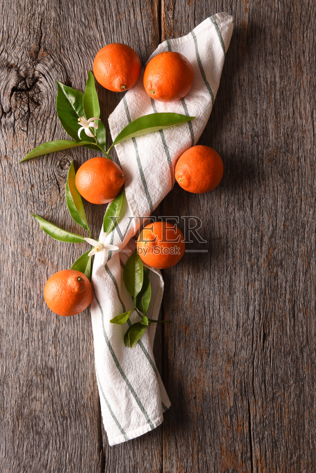 一组水果的特写镜头，一条毛巾和树叶在一个质朴的木头桌子上。照片摄影图片