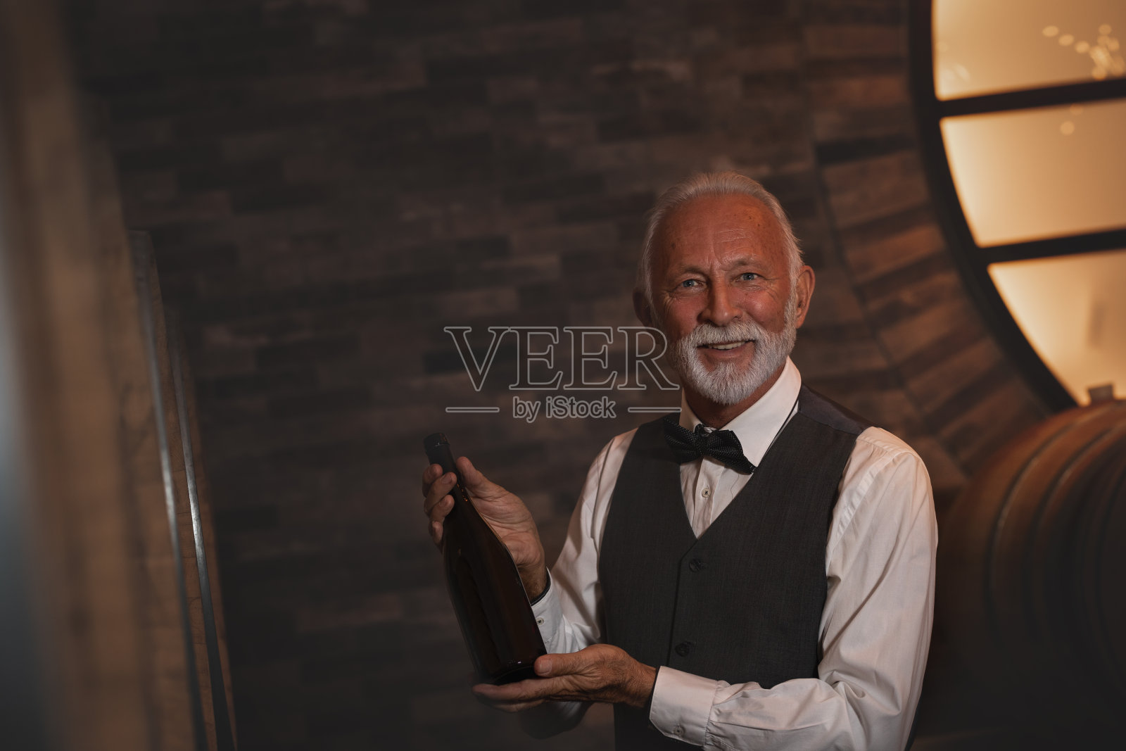 一个人在酒窖里拿着一瓶酒照片摄影图片