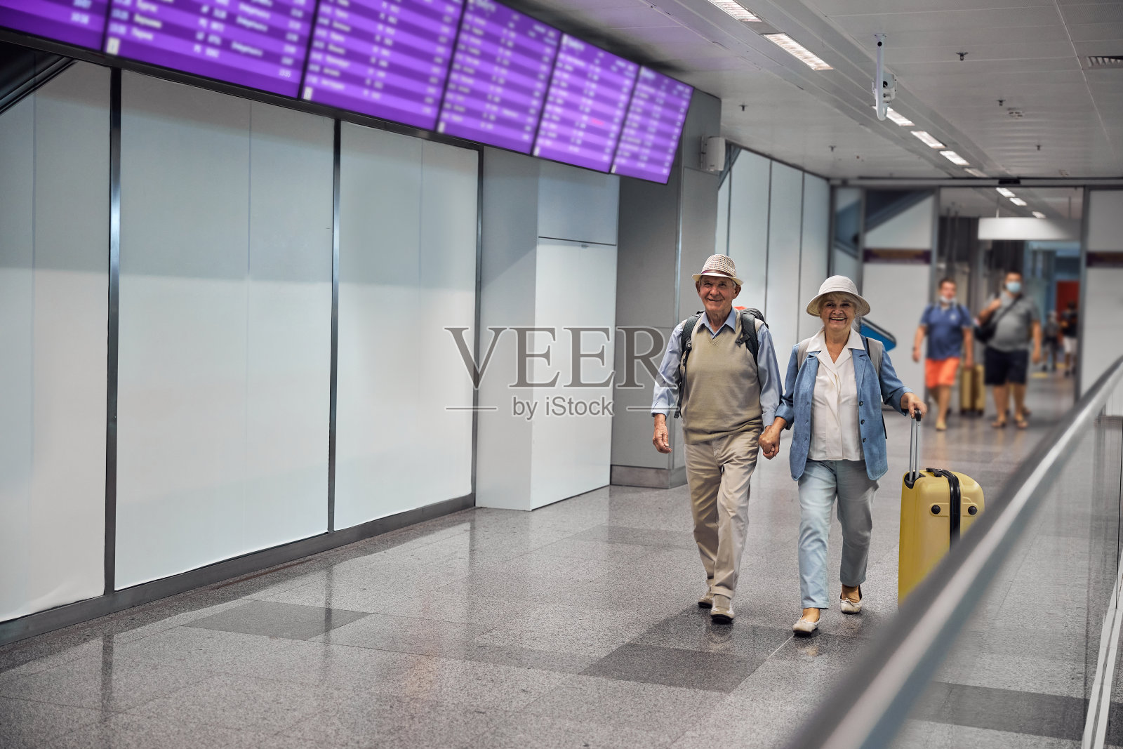 一对快乐的夫妇沿着机场候机楼散步照片摄影图片