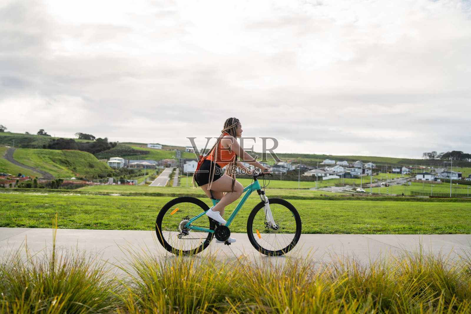 骑自行车的年轻女子。照片摄影图片