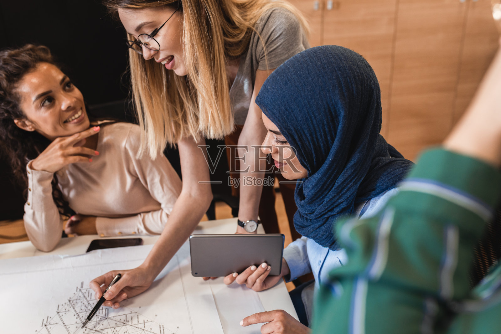 一群现代多元文化的年轻女性在创意办公室。照片摄影图片