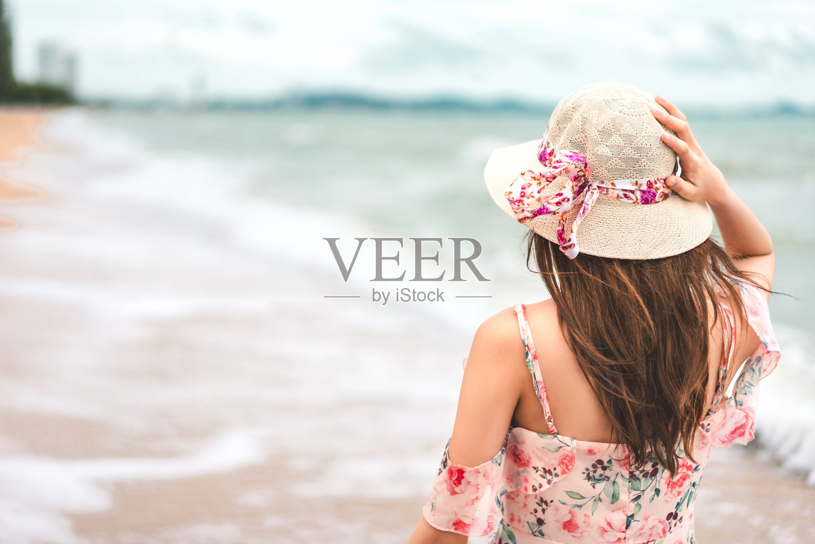 年轻的成年亚洲女人穿着和帽子放松漫步在海滩上照片摄影图片