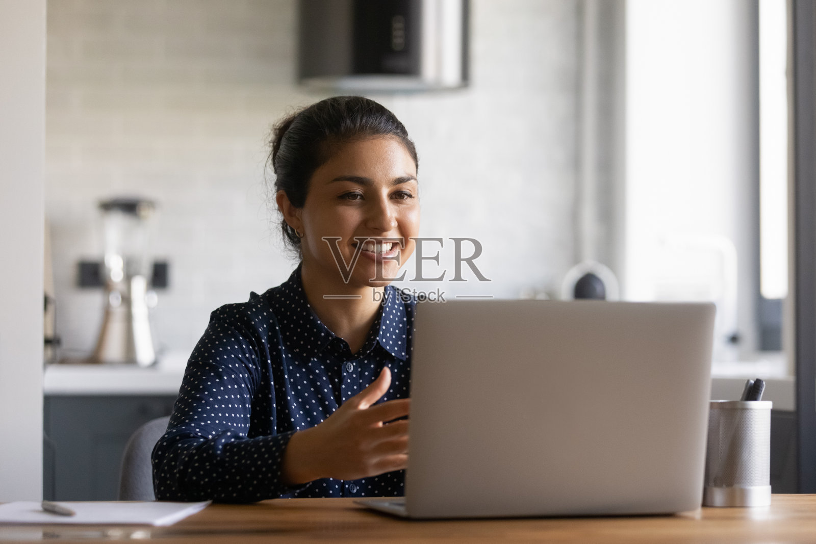 微笑的印度妇女看着笔记本电脑屏幕工作照片摄影图片