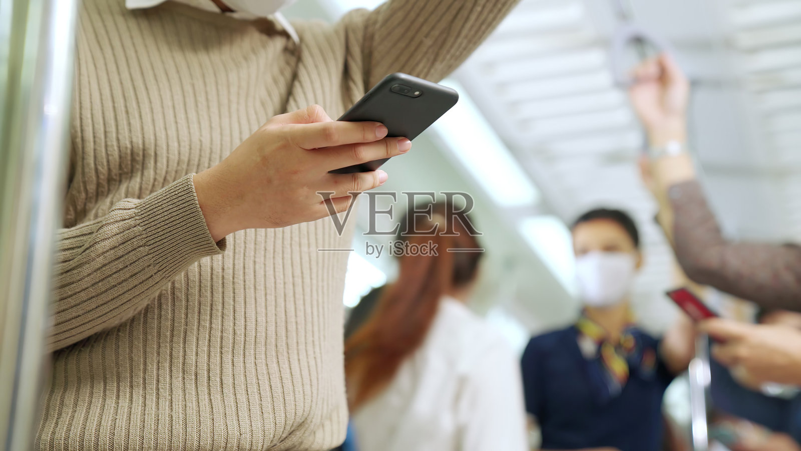 一群戴着口罩乘坐拥挤的地铁出行的人照片摄影图片