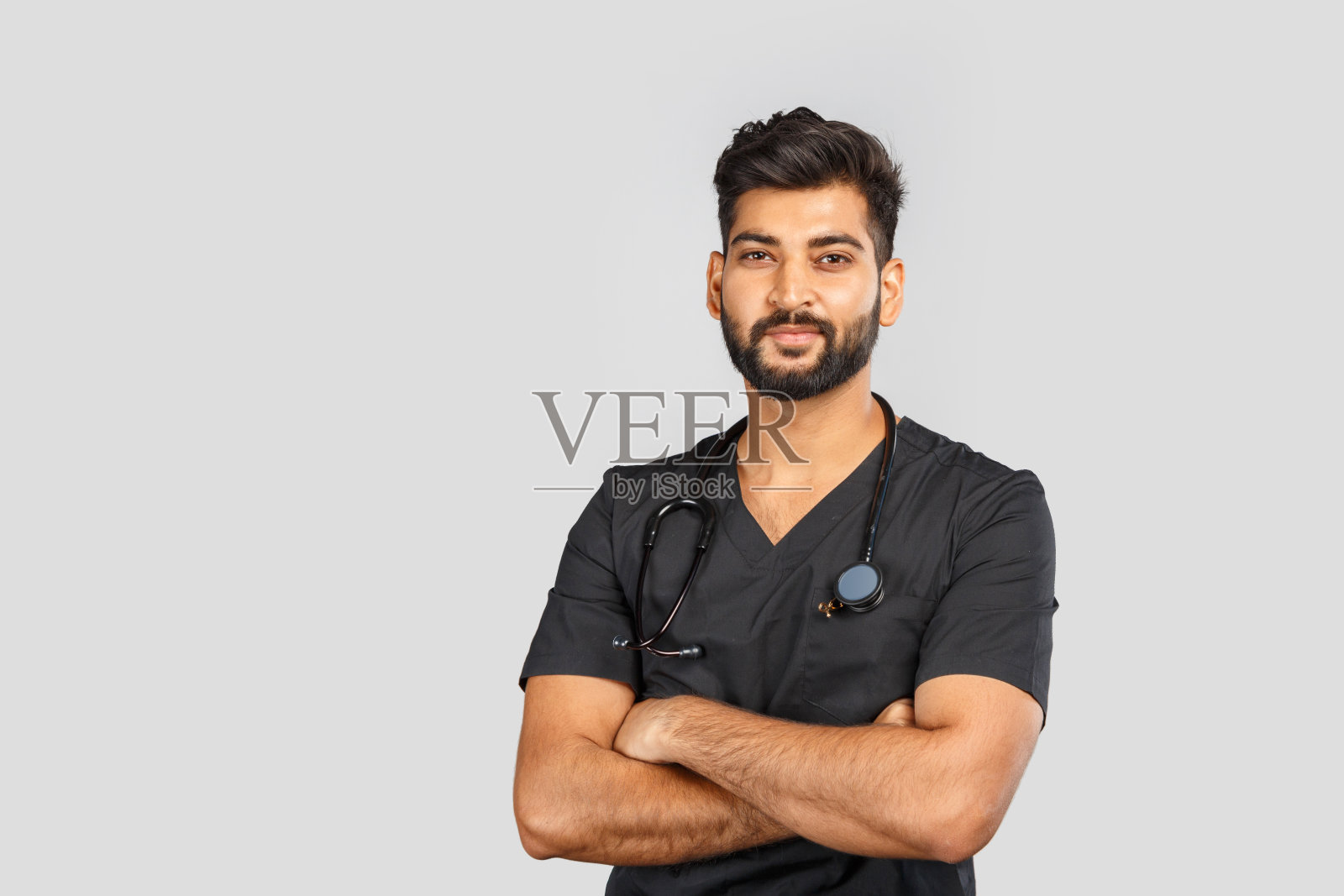 可爱微笑的印度医生或外科医生在黑色制服与听诊器在灰色背景照片摄影图片
