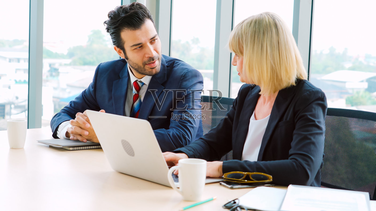 两位商务人士在办公室谈论项目策略照片摄影图片