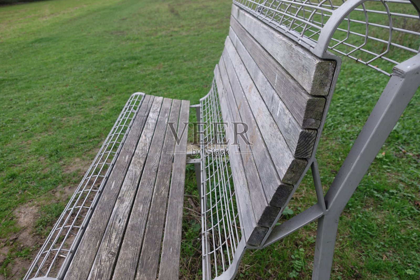 由木材和钢铁制成的公共长椅安排在草地上照片摄影图片