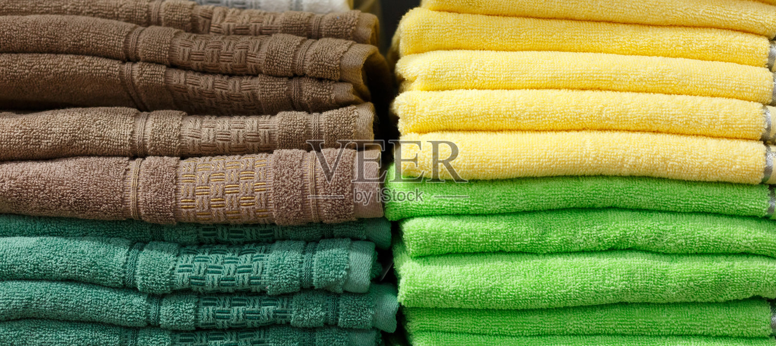 五颜六色的毛巾在店里的架子上一堆堆地摆放着，纺织品部在店里照片摄影图片