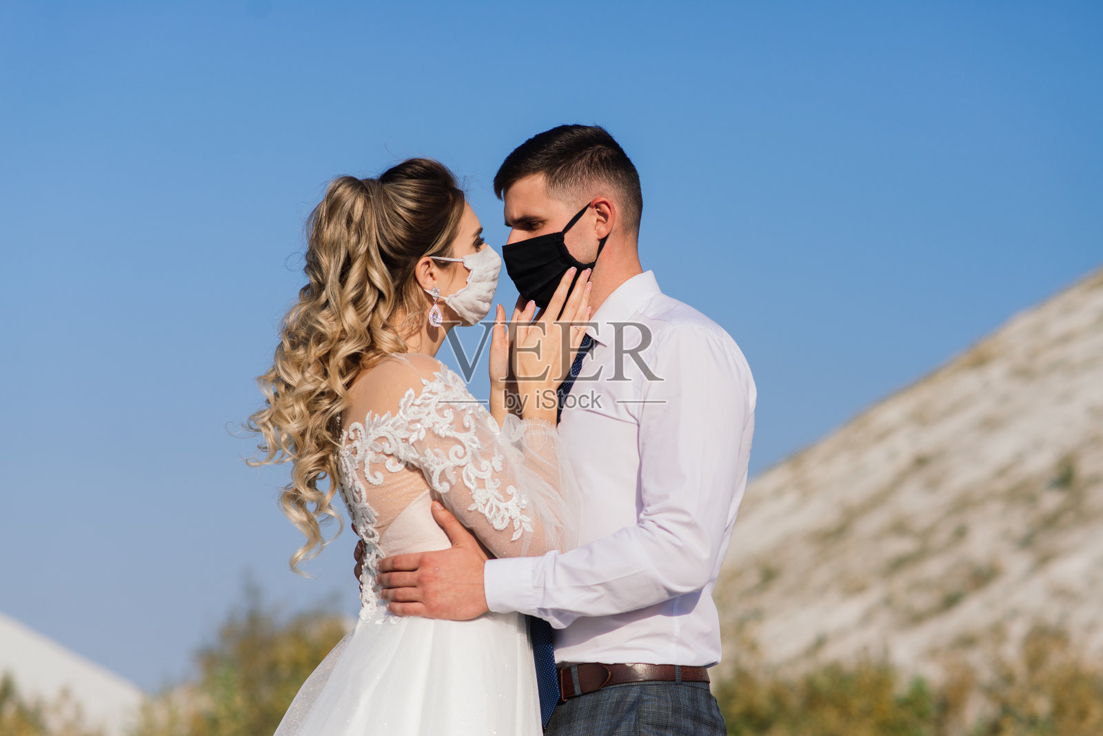 新婚当天，一对年轻情侣戴着医用口罩在公园隔离。照片摄影图片