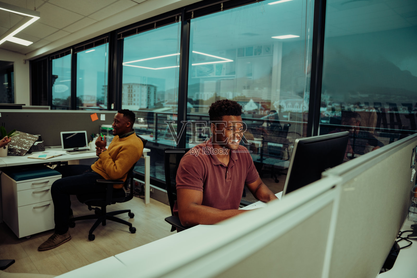 混合种族的男性设计师在办公室用台式电脑打字市场报告照片摄影图片