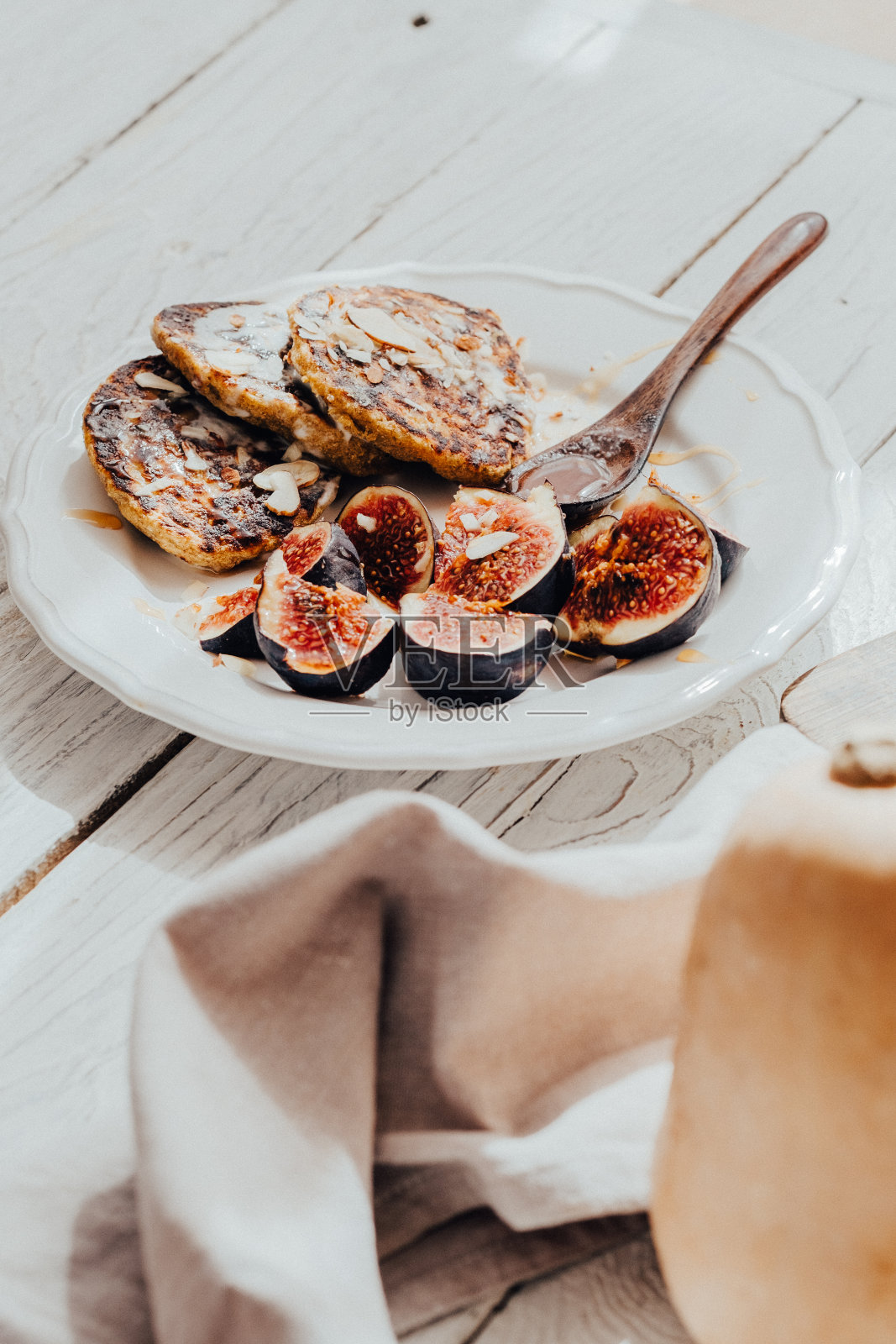 白色木桌上放着南瓜煎饼和无花果照片摄影图片