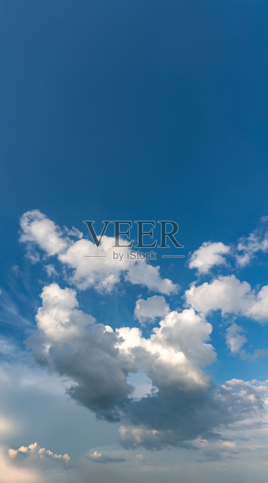 梦幻般的云朵映衬着蓝天，垂直的全景照片摄影图片