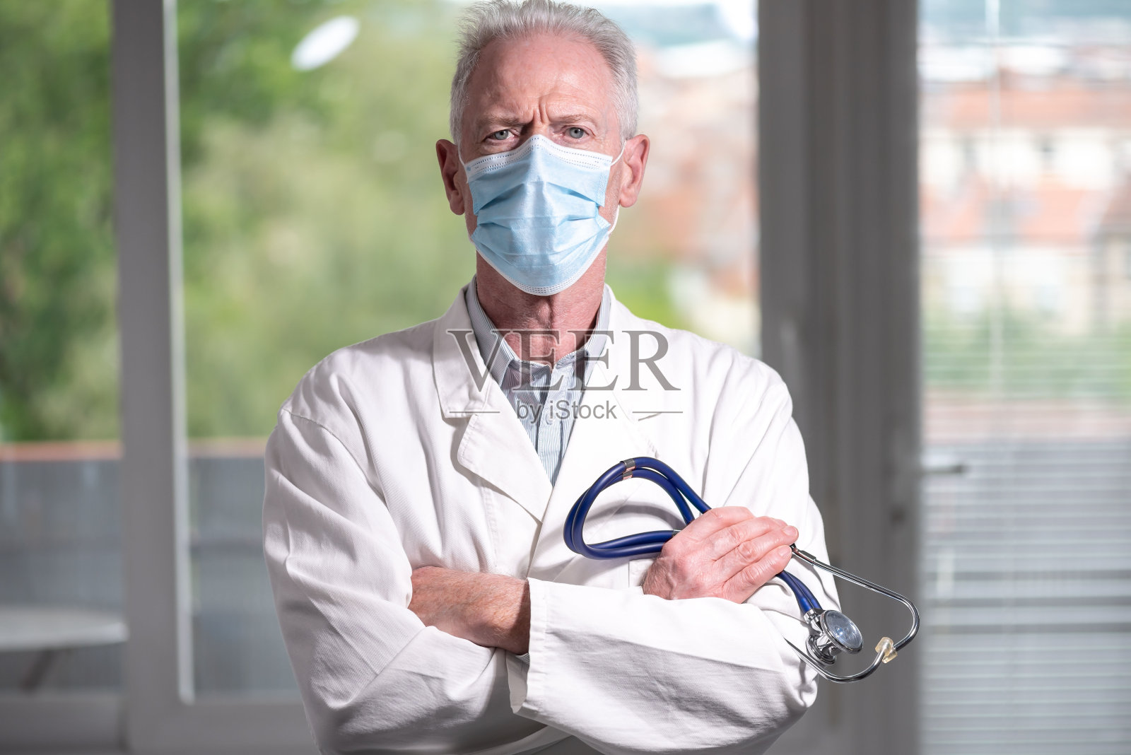 医生的肖像与双臂交叉戴着口罩照片摄影图片