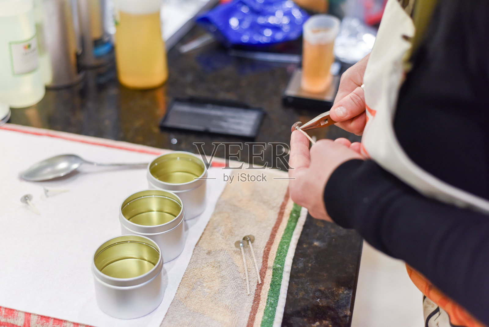 制作蜡烛的人会调整灯芯的长度，并加入蜡烛蜡照片摄影图片