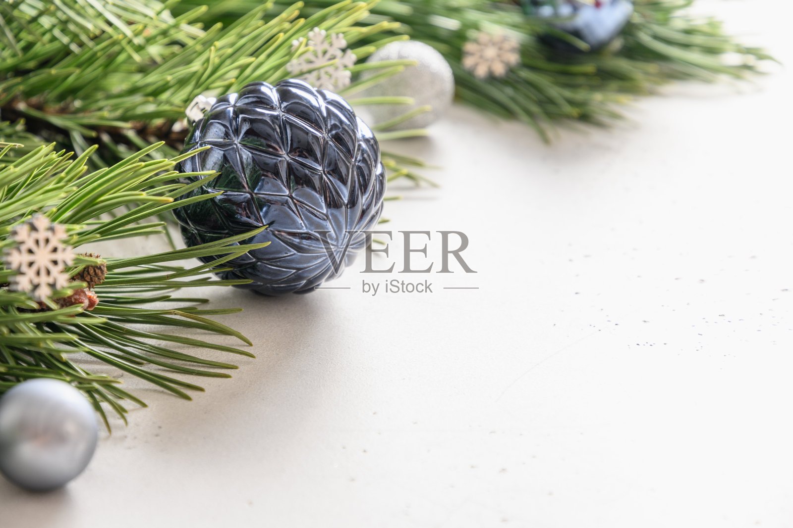 用蓝色的装饰物和常青树的树枝在白色的圣诞作文。照片摄影图片