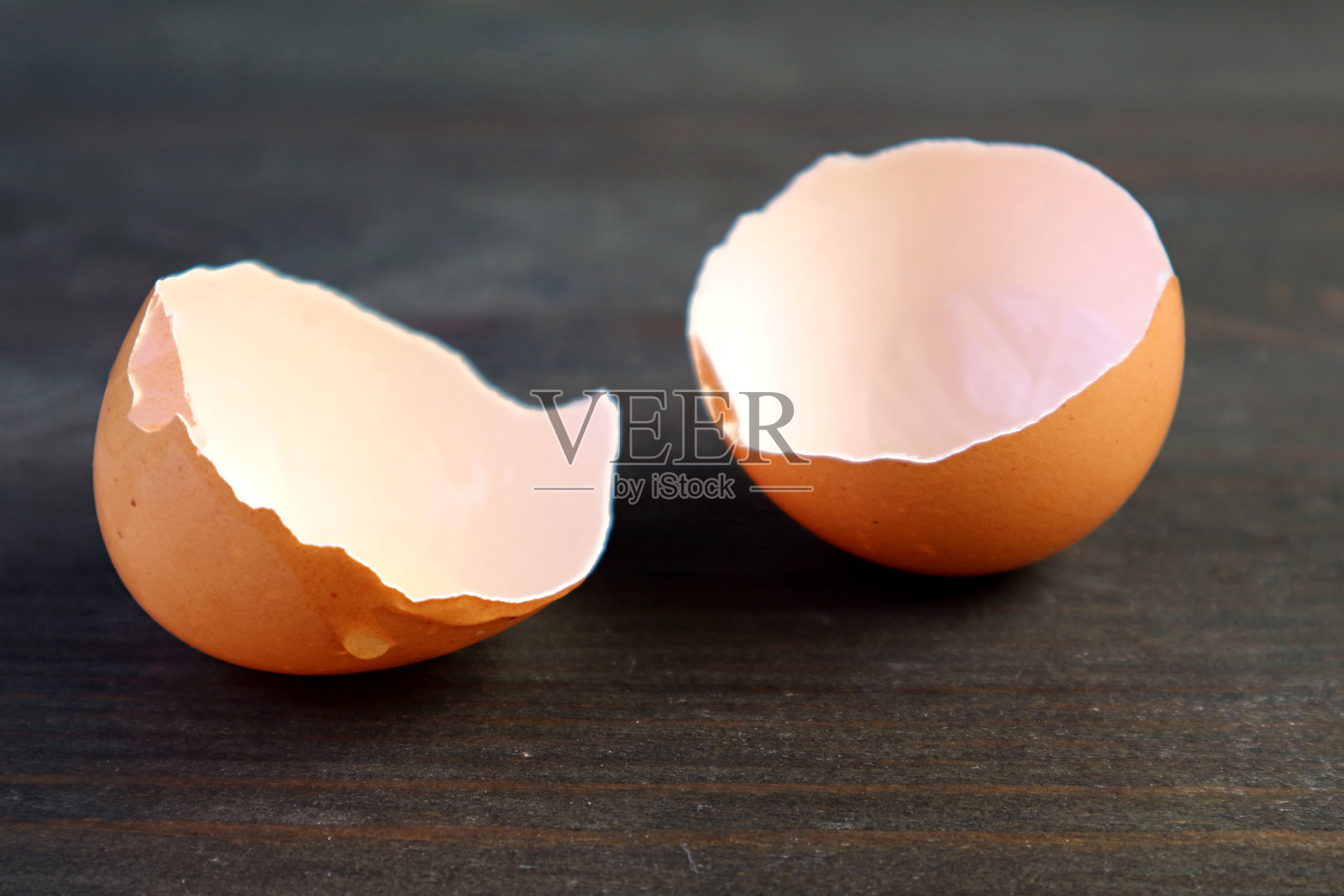 特写破碎的蛋壳孤立在深棕色的木桌上照片摄影图片