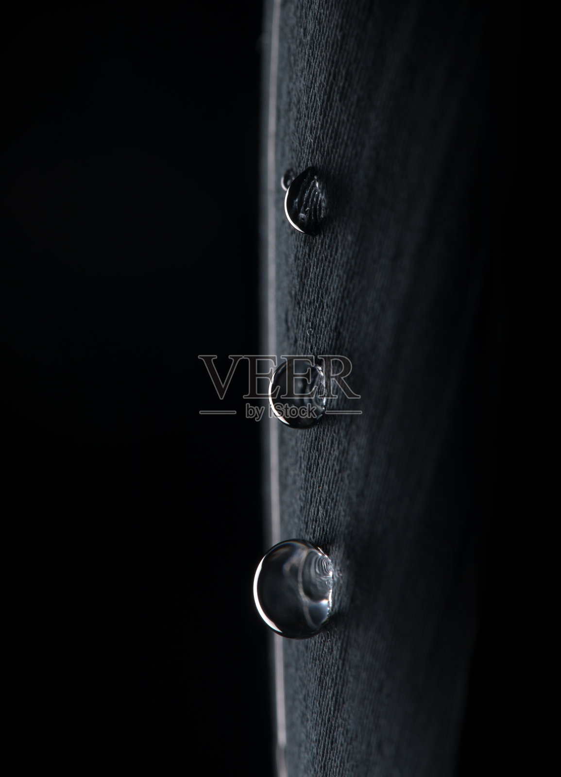 背景:水滴落在黑色羽毛上照片摄影图片