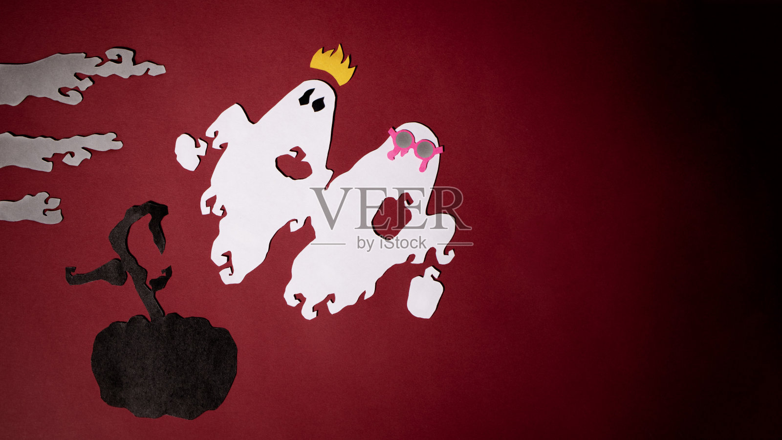 红色背景的雾中，节日的幽灵飞过一个黑色的南瓜照片摄影图片