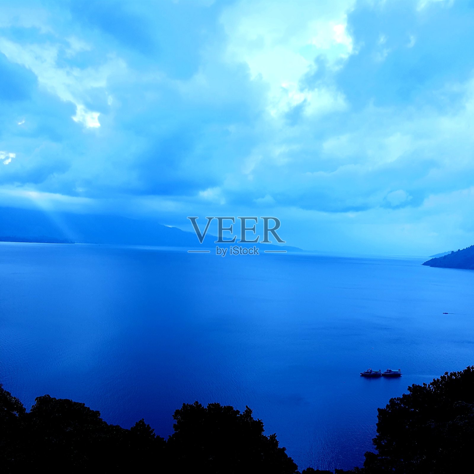 蓝色的湖，云和船照片摄影图片