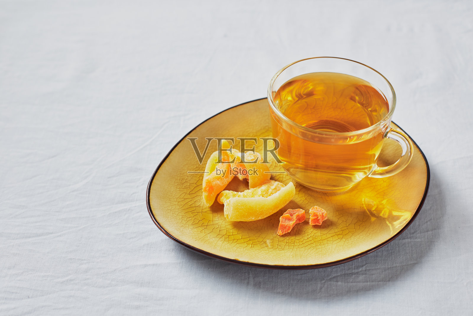 美味的红茶在玻璃杯和糖果水果在黄色的托盘照片摄影图片