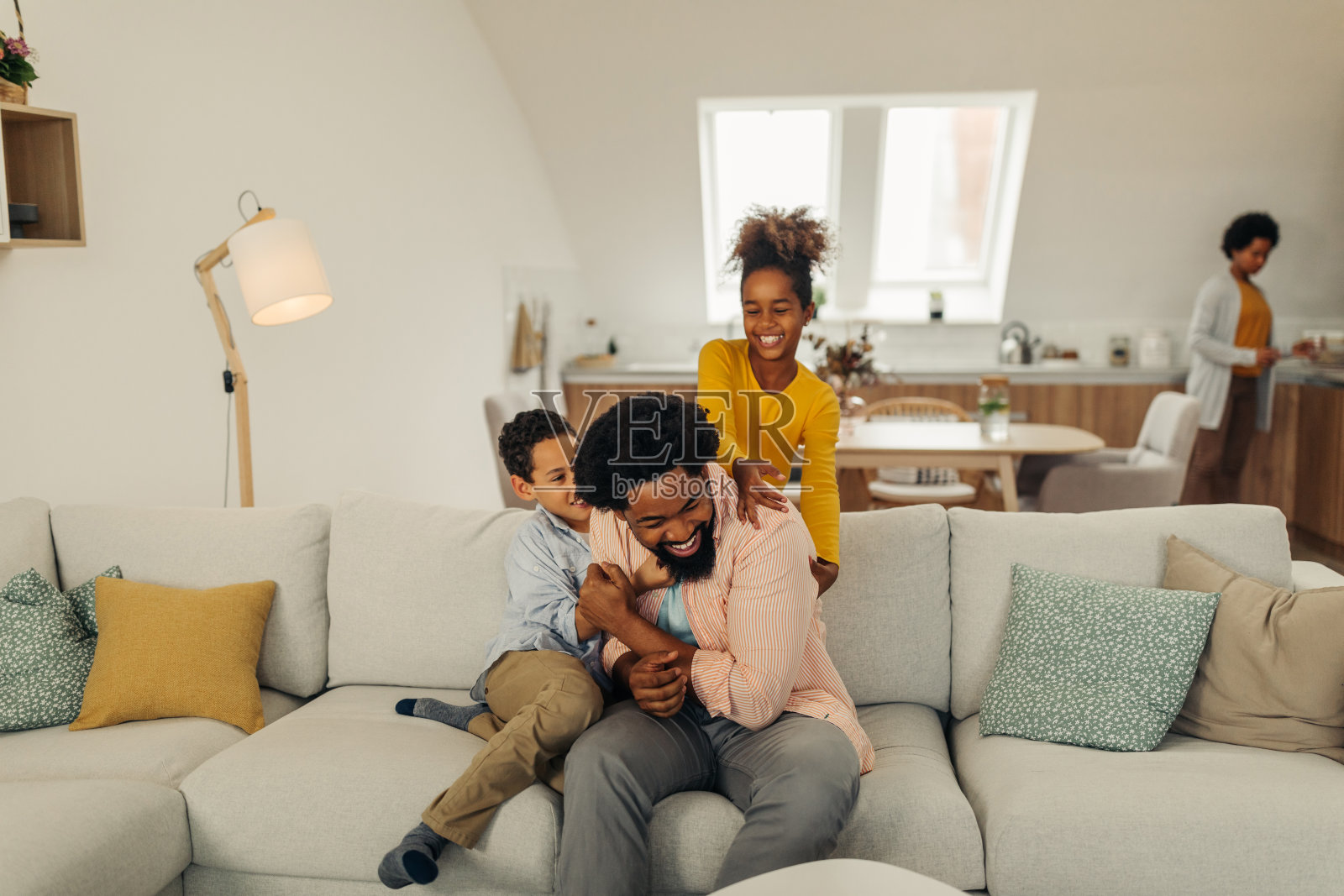 非洲裔的孩子们在舒适的客厅里和他们的父亲玩得很开心照片摄影图片