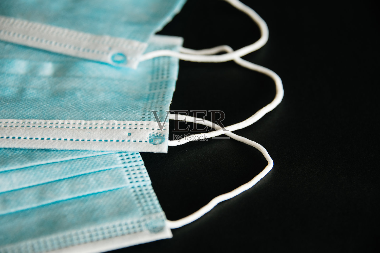 三个黑色背景的外科防护口罩照片摄影图片