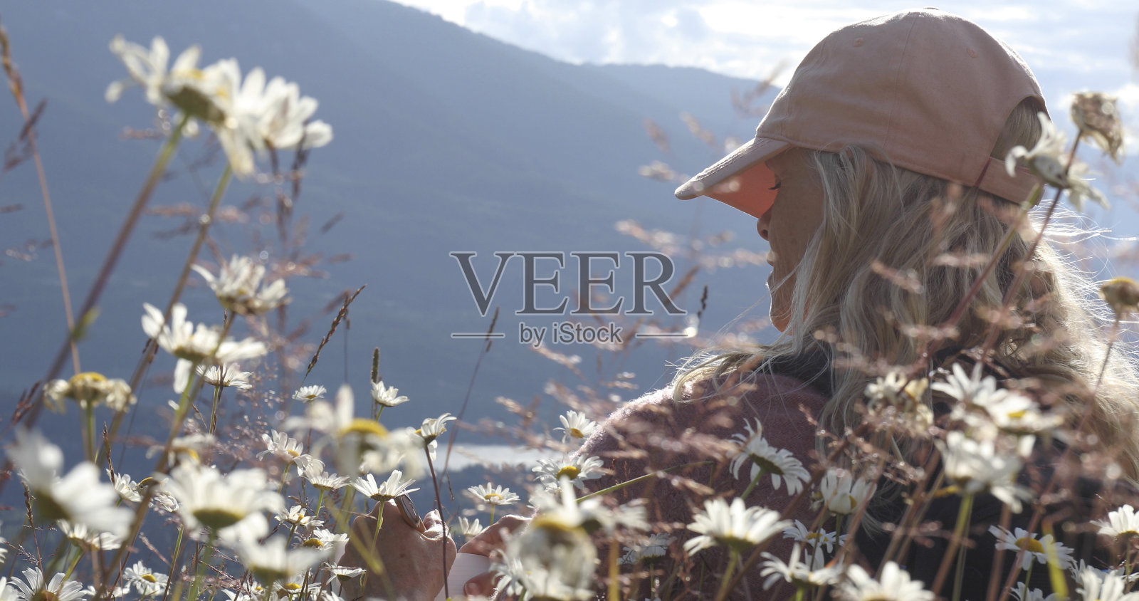 女性徒步旅行者在早晨在高山草甸放松照片摄影图片