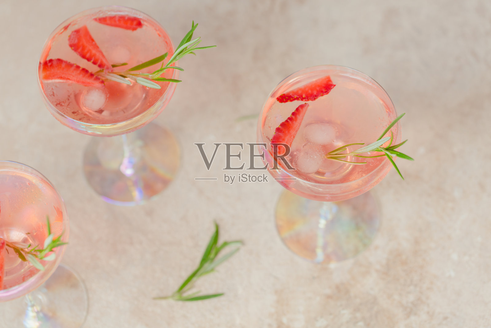 一杯草莓苏打饮料在米色的沙子背景。夏季健康排毒柠檬水，鸡尾酒或其他饮料背景。非酒精饮料，超级食物，素食或健康饮食概念。照片摄影图片