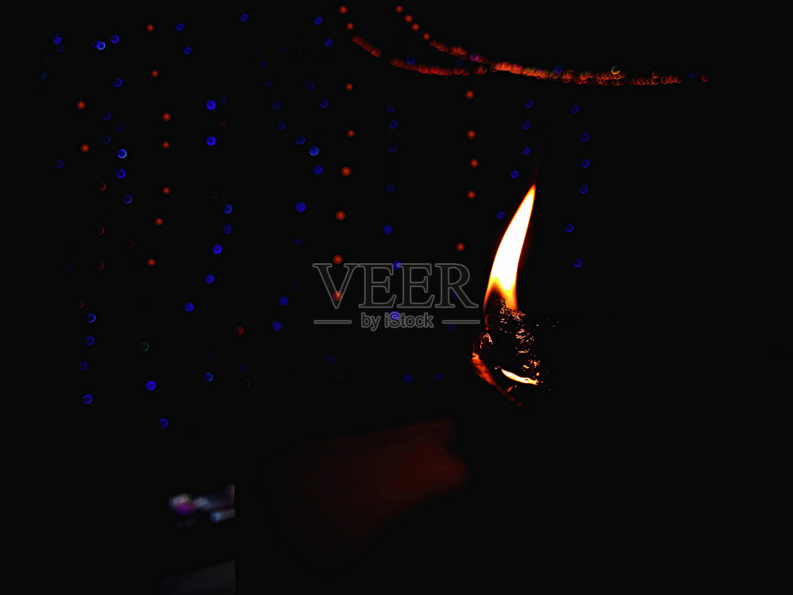 快乐的排灯节-在排灯节庆祝活动的前景在晚上与灯光散景效果在背景点燃多彩的粘土Diya灯。照片摄影图片