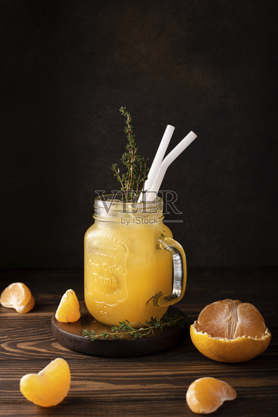 玻璃杯里的橘子汁加冰和百里香枝照片摄影图片