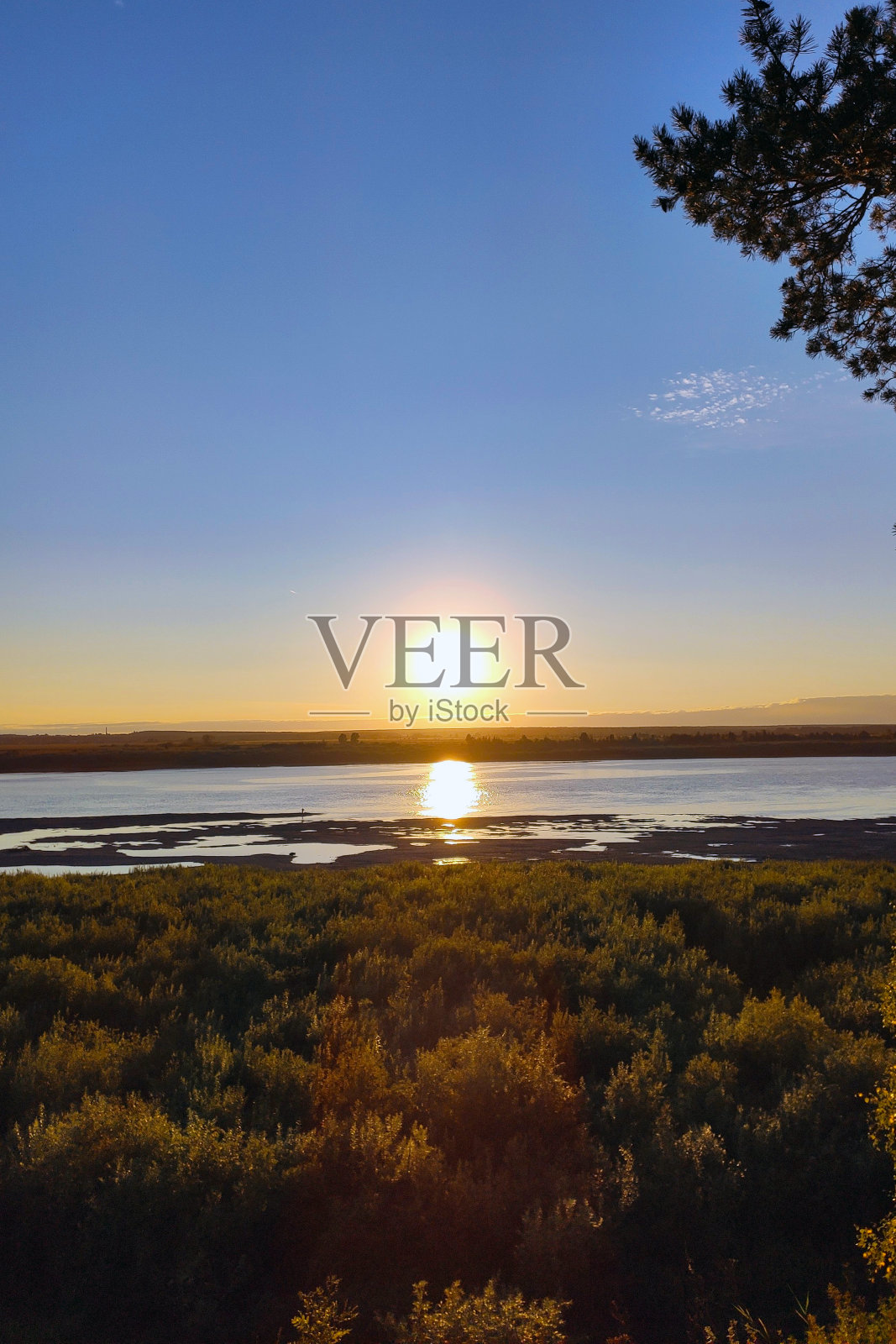 地平线上的夕阳。阳光在水中的反射照片摄影图片