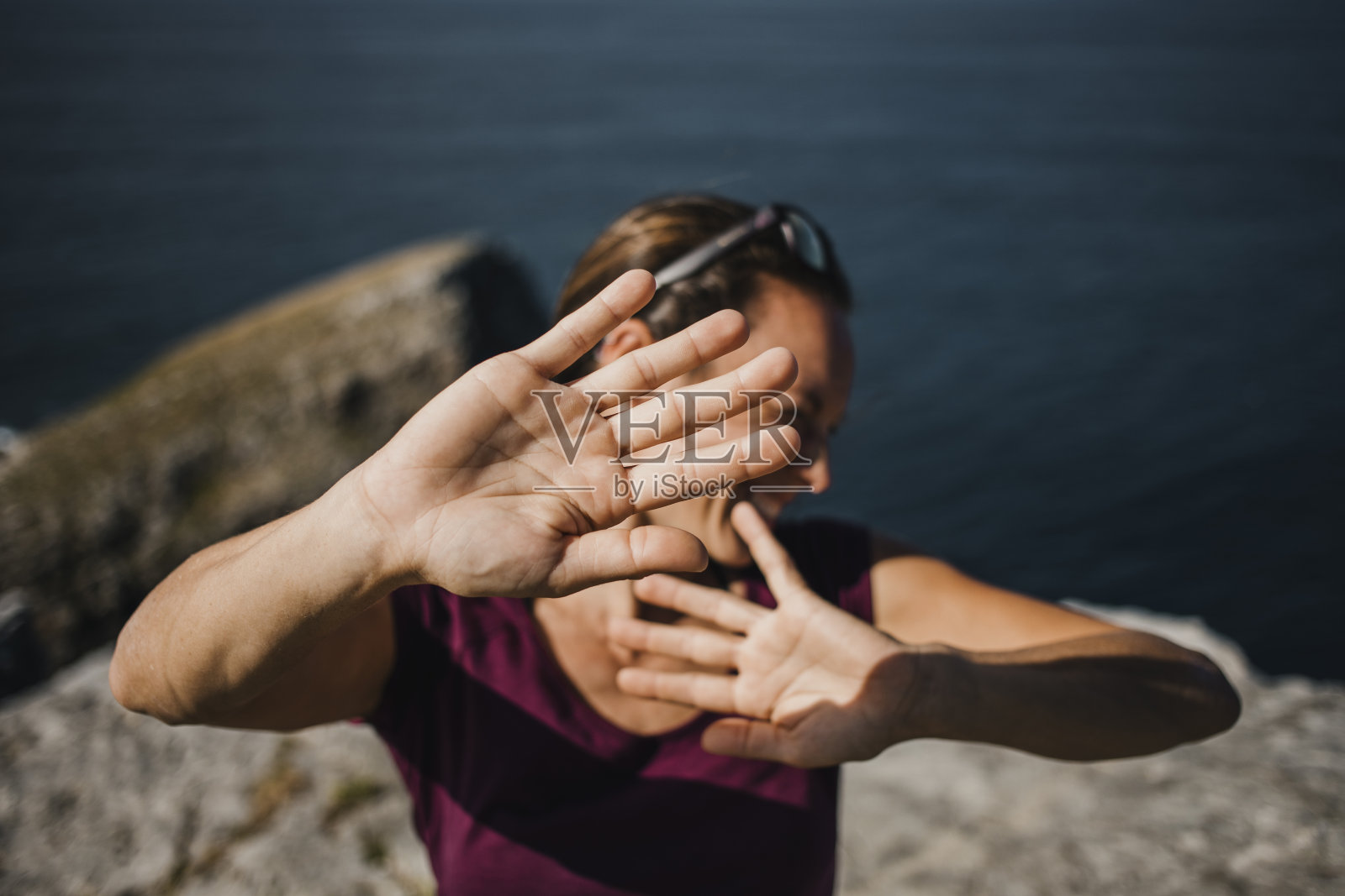顽皮的女人试图躲避摄影师的相机，以避免被拍到。照片摄影图片