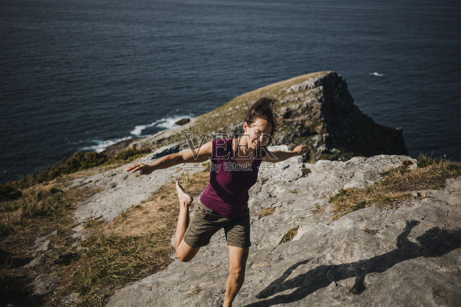 一个女人在悬崖前蹦蹦跳跳照片摄影图片