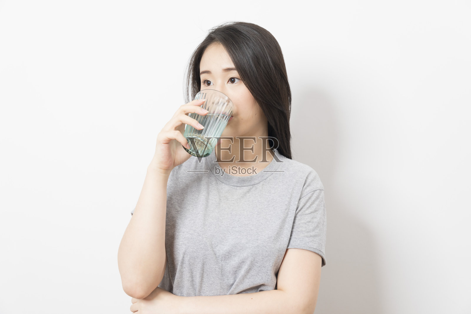 快乐的亚洲女人手里拿着一杯水。照片摄影图片