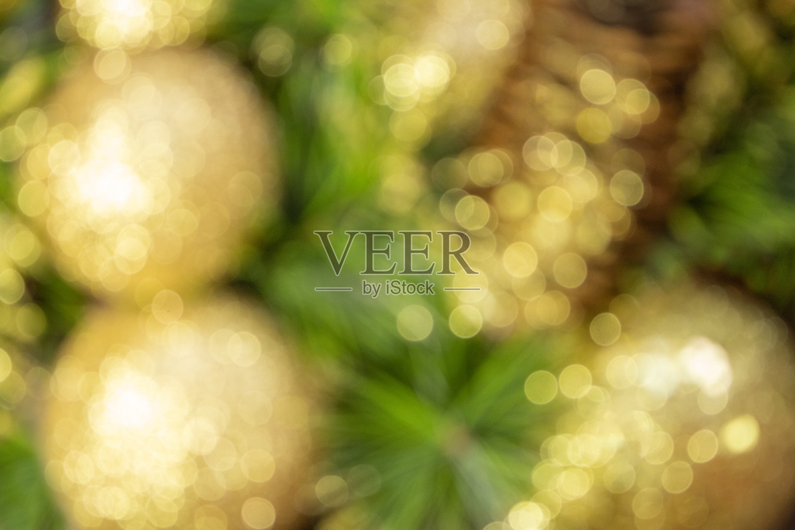 抽象模糊的黄色圣诞球和圆锥体与树皮和松树枝。新年贺卡。背景照片摄影图片