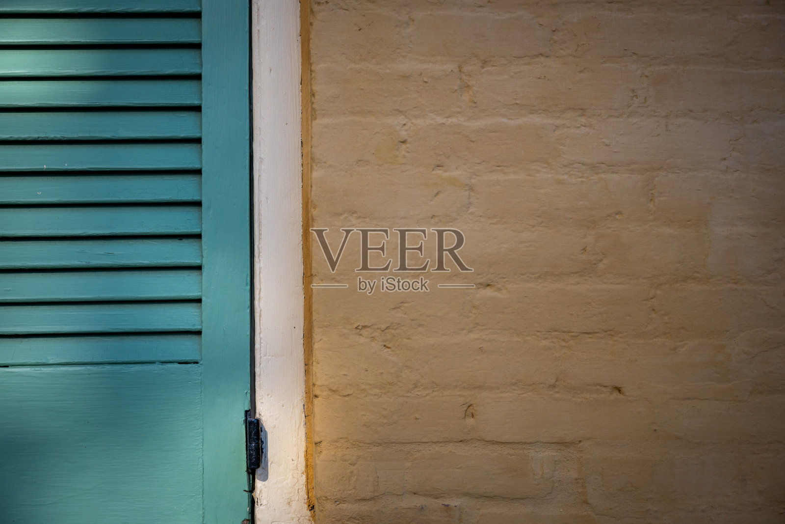 青色百叶窗和黄色砖墙照片摄影图片