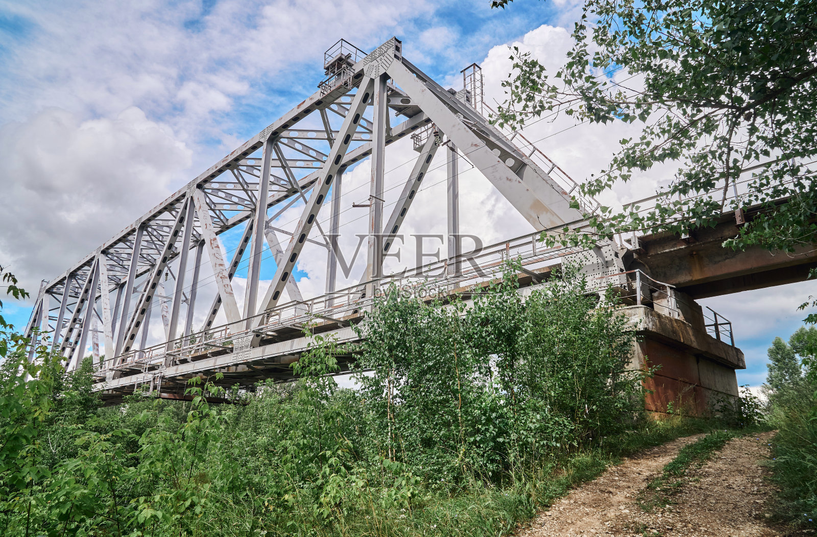 铁路桥横跨河上，天空阴云密布照片摄影图片