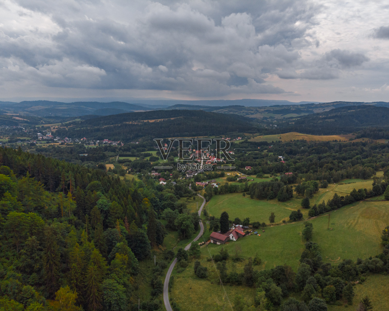 在猫头鹰山附近的灌木丛和树木之间的长路径到城市照片摄影图片