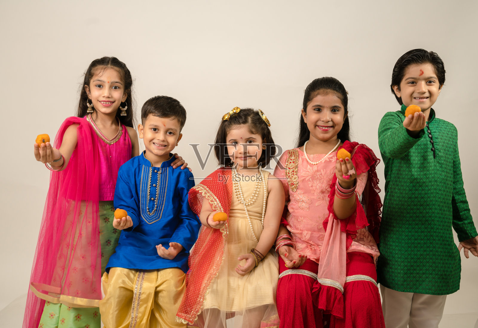 孩子们穿着民族服装在工作室享受照片摄影图片