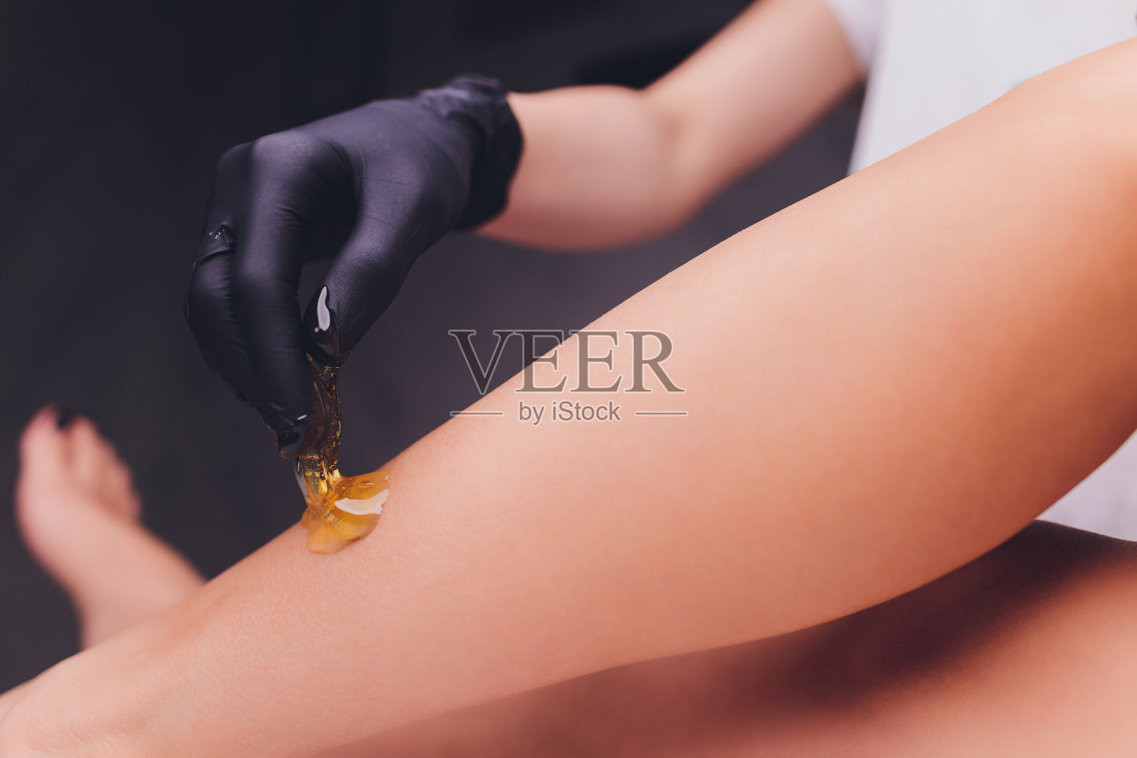 加糖:在腿处用溶解的糖脱毛。照片摄影图片