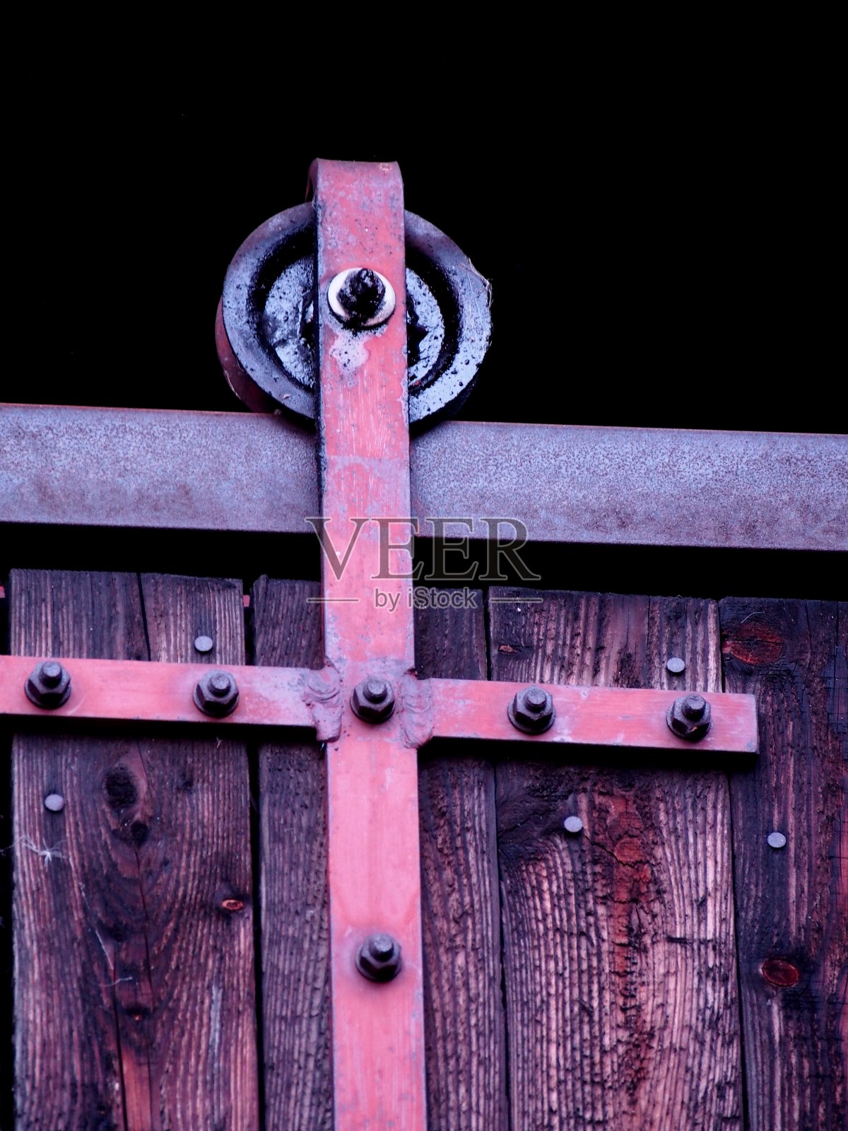 滑动谷仓门，轨道上车轮的细节，带有金属滑动机构的旧棕色大门，技术解决方案照片摄影图片