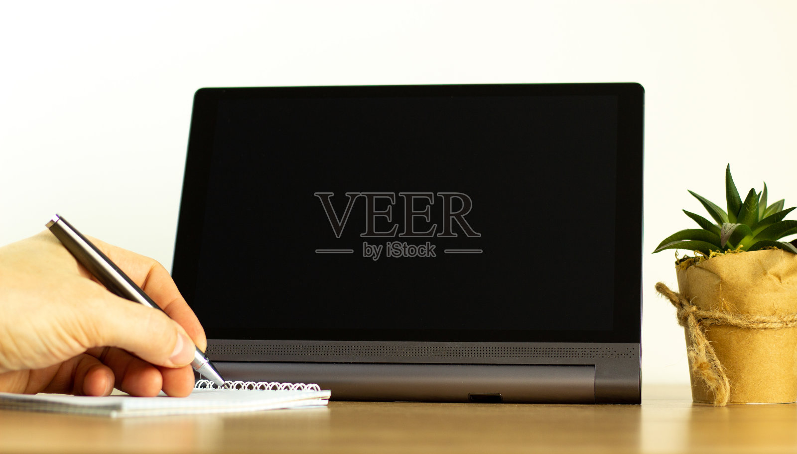 教育与经营理念。空白屏幕的平板电脑为您的文本。男手拿笔，房栽。副本的空间。照片摄影图片