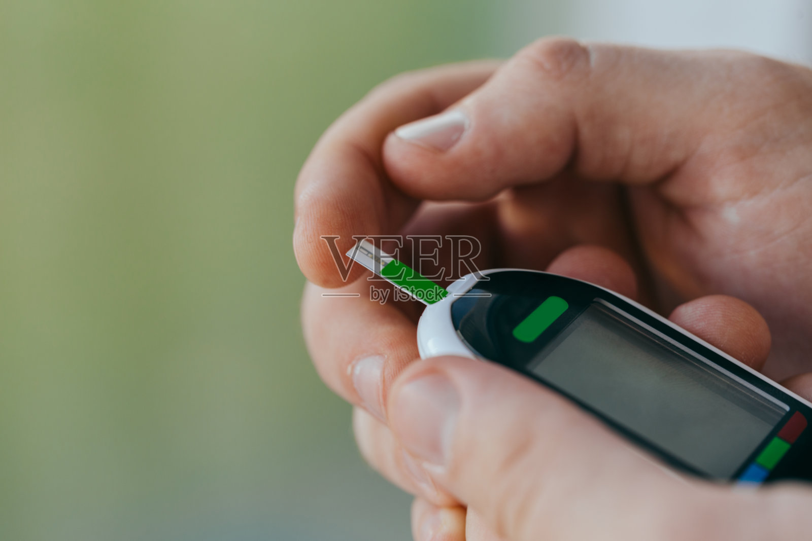 医学，糖尿病，血糖，保健和人们的概念-爱在家用血糖仪和测试条检查血糖。糖尿病日，11月14日。照片摄影图片