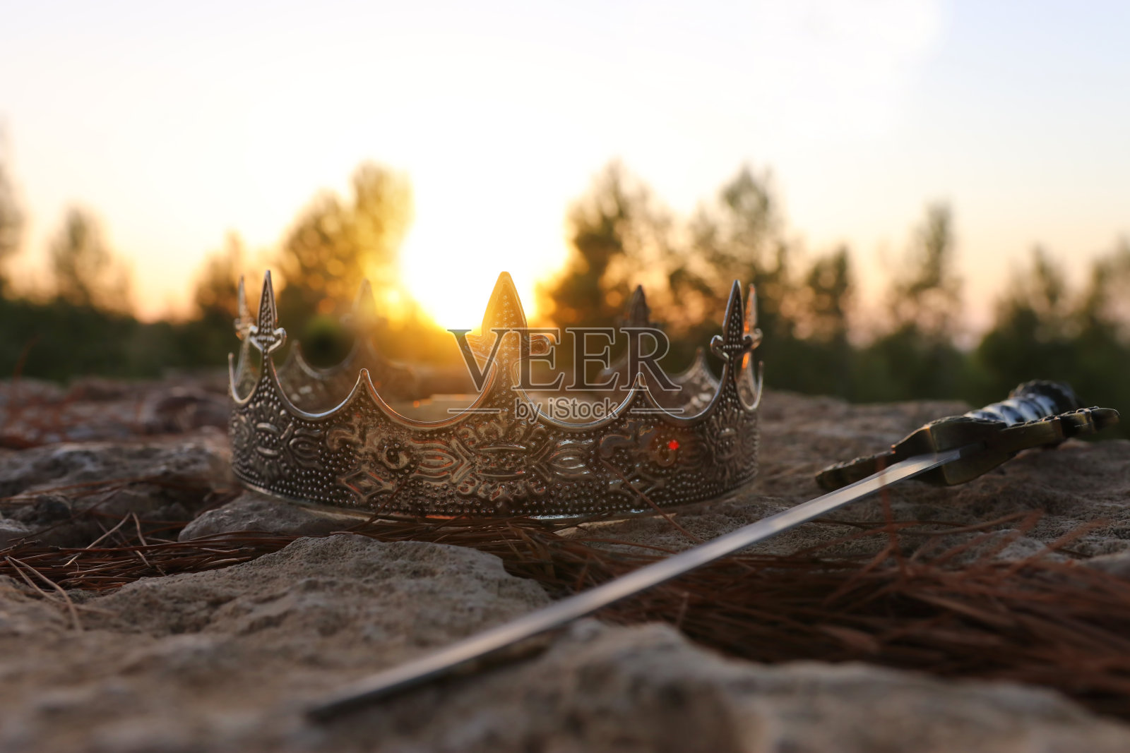 神秘而神奇的照片，银色的国王皇冠和剑在英国森林的石头。中世纪的概念。照片摄影图片
