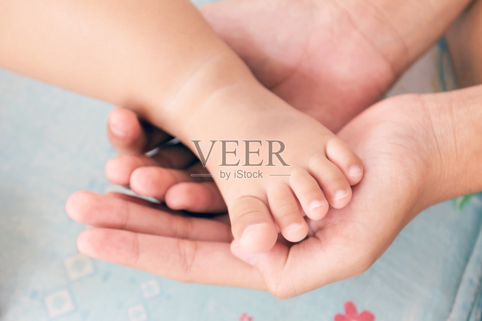 母亲的手摇着婴儿的脚照片摄影图片