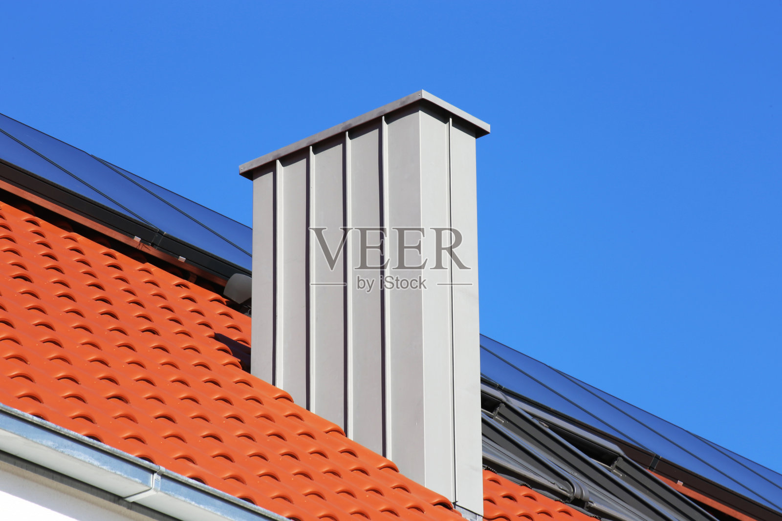 在新覆盖的屋顶上有不锈钢覆盖层的烟囱照片摄影图片