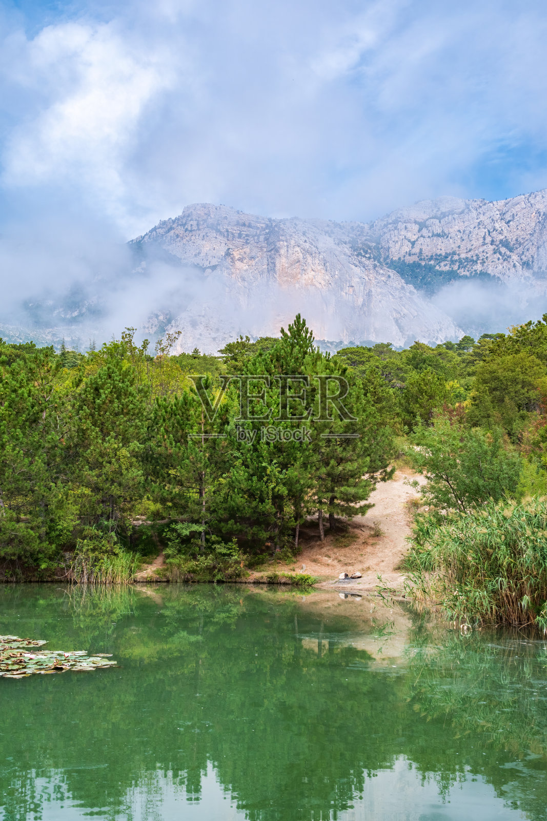 湖在山上，岸边有松树照片摄影图片