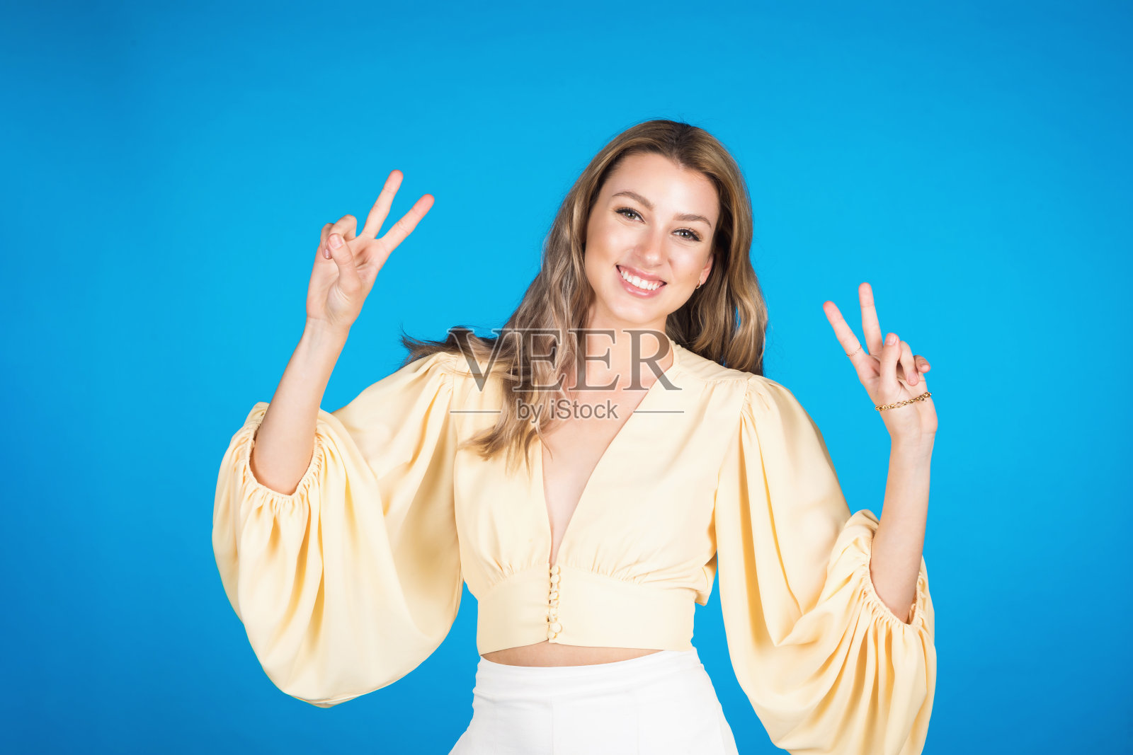 浅蓝色背景上的年轻女子的肖像照片摄影图片