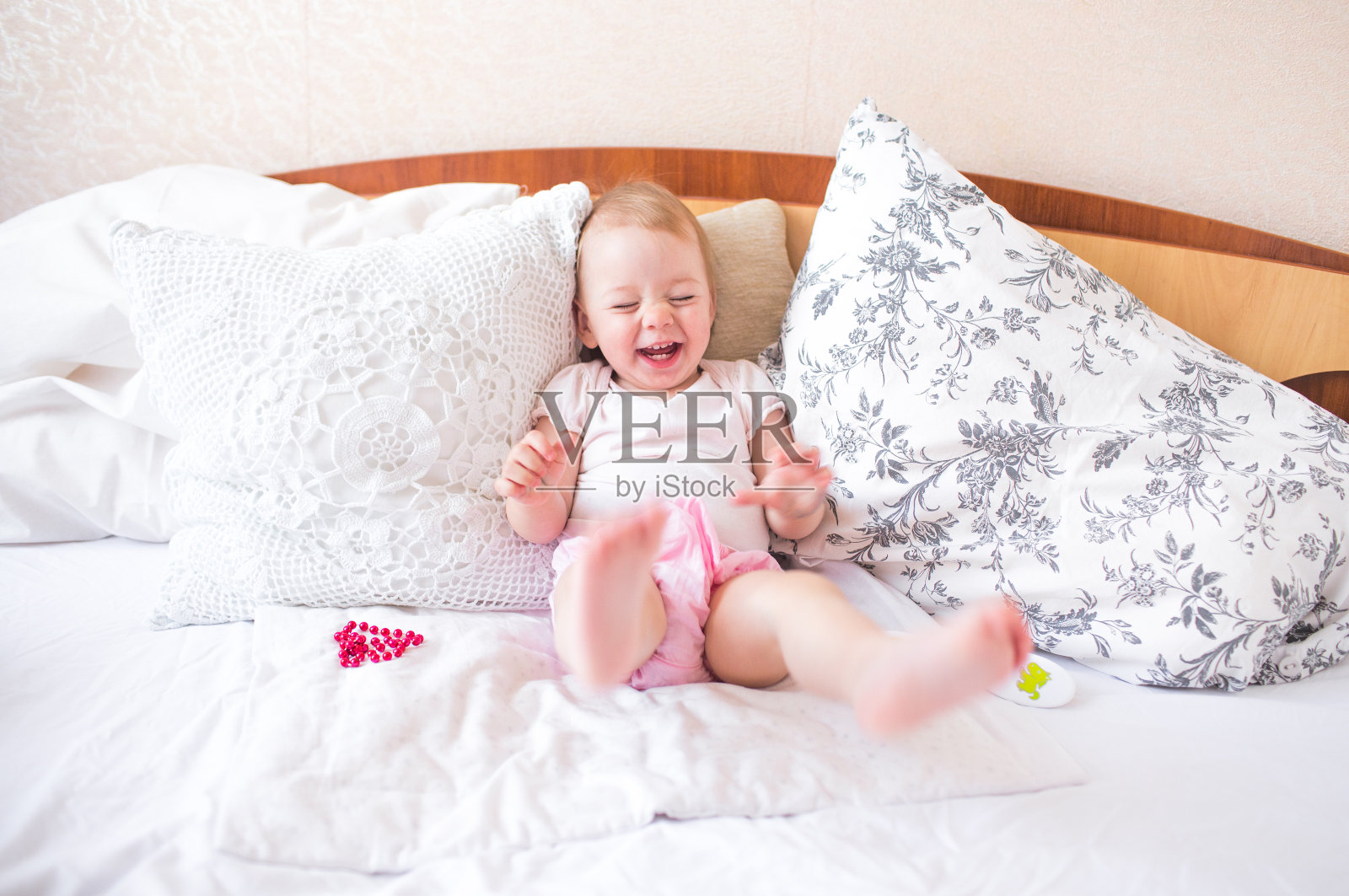 可爱的小女孩在床上玩，笑着照片摄影图片