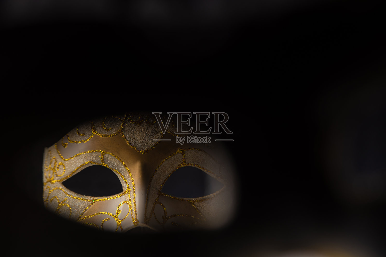 嘉年华威尼斯面具黑色表面，低调形象，定向光，选择性聚焦。照片摄影图片